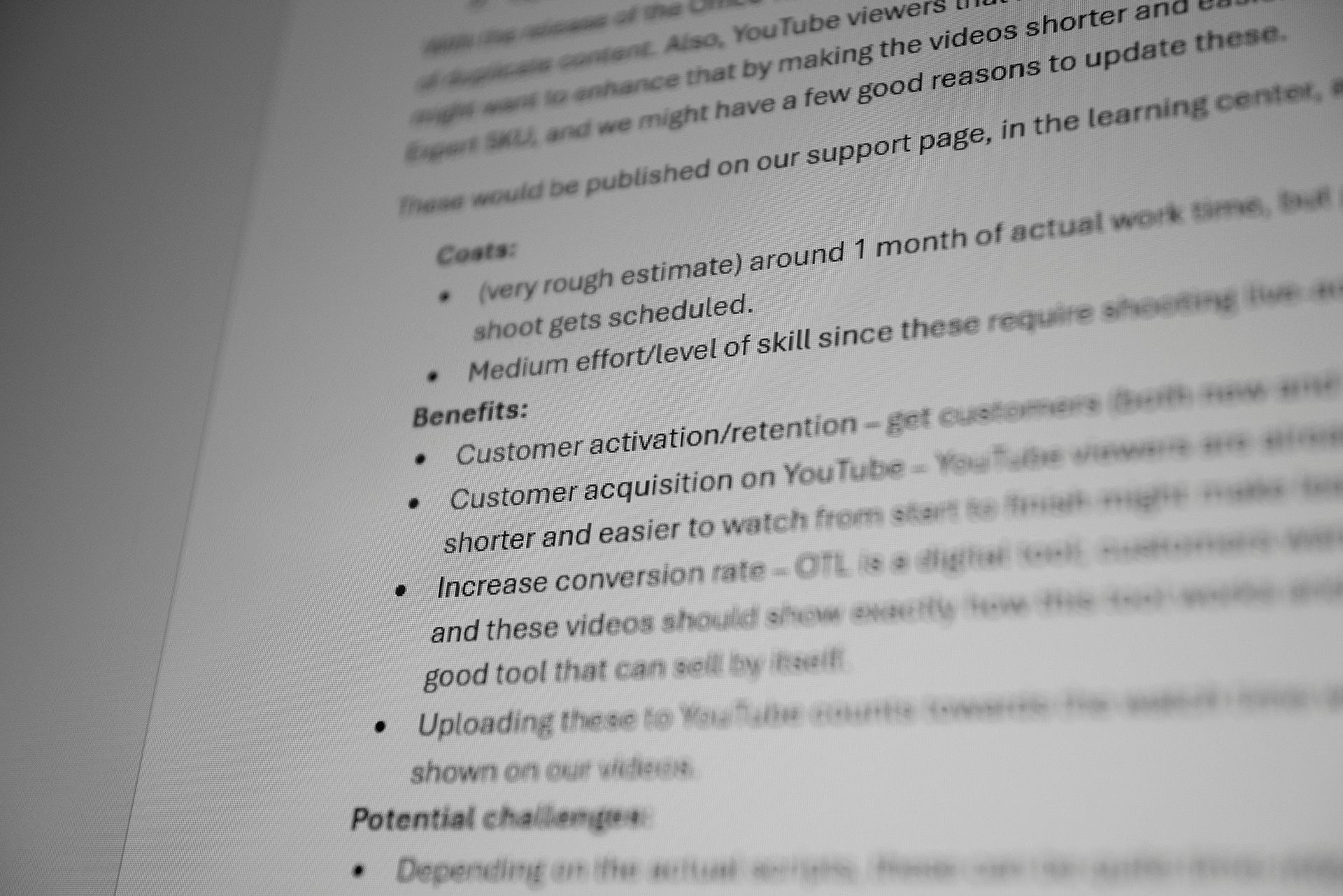 Blurred close-up of a strategy document listing costs, benefits and potential challenges for video content